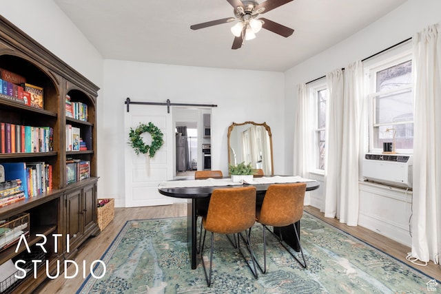 2516 S Orchard Ave, Ogden, UT 84401 - dining space featuring a barn door, cooling unit, a ceiling fan, and light wood-type flooring