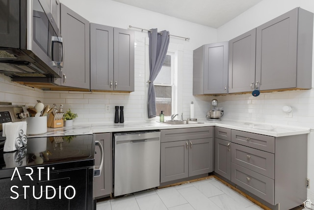 2516 S Orchard Ave, Ogden, UT 84401 - kitchen featuring tasteful backsplash, gray cabinetry, stainless steel appliances, and a sink