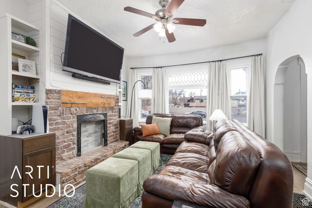 2516 S Orchard Ave, Ogden, UT 84401 - living room with a ceiling fan, wood finished floors, a fireplace, and arched walkways