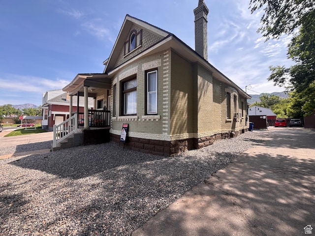 2516 S Orchard Ave, Ogden, UT 84401 - view of side of home with a chimney, brick siding, and a mountain view