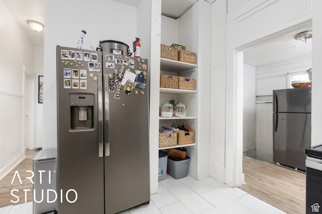 2516 S Orchard Ave, Ogden, UT 84401 - kitchen featuring light wood-style flooring, white cabinets, stainless steel refrigerator with ice dispenser, and freestanding refrigerator