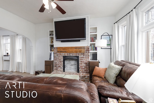 2516 S Orchard Ave, Ogden, UT 84401 - living area featuring arched walkways, a brick fireplace, and ceiling fan
