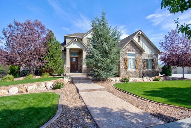 craftsman house with board and batten siding, a front lawn, and stone siding