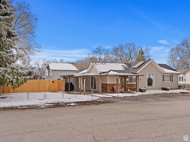 3911 W 2250 N, Corinne, UT 84307 - view of front facade with roof mounted solar panels, an attached carport, and fence
