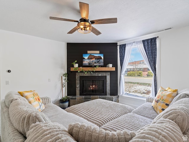 3911 W 2250 N, Corinne, UT 84307 - living room featuring visible vents, a textured ceiling, a ceiling fan, and a tile fireplace