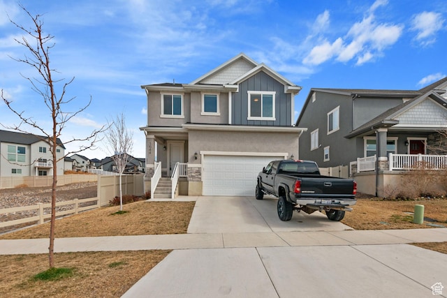 view of front of house with board and batten siding, fence, concrete driveway, stucco siding, and an attached garage