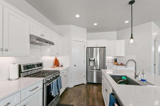 kitchen with under cabinet range hood, stainless steel appliances, dark wood-style floors, white cabinetry, and a sink