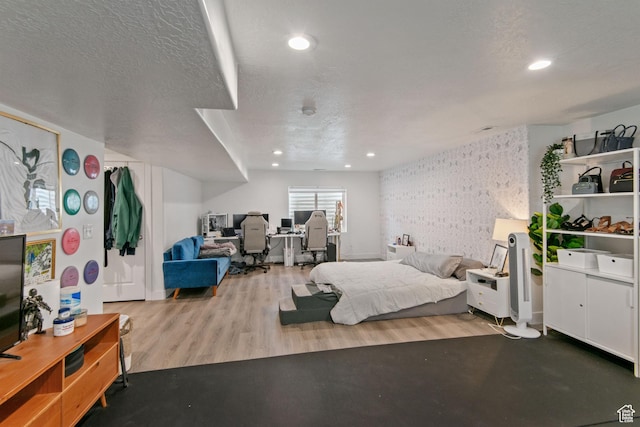 bedroom featuring recessed lighting, wood finished floors, and a textured ceiling