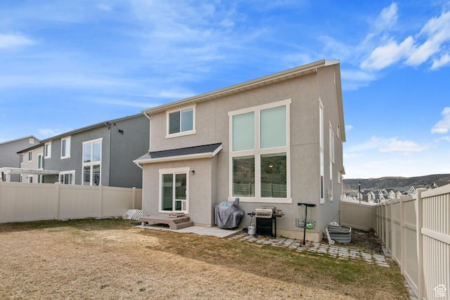 rear view of property with a fenced backyard and stucco siding