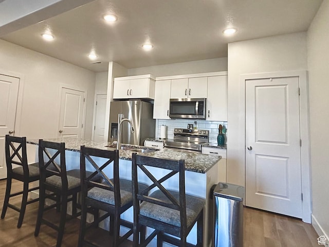 337 S 1540 E, Hyrum, UT 84319 - kitchen with a sink, tasteful backsplash, appliances with stainless steel finishes, and a breakfast bar