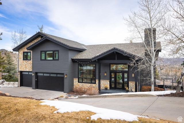 4673 Nelson Ct, Park City, UT 84098 - view of front of house featuring a garage, driveway, stone siding, a chimney, and a shingled roof