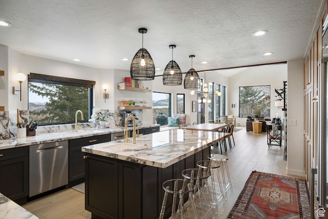 4673 Nelson Ct, Park City, UT 84098 - kitchen with dishwasher, a sink, a kitchen island with sink, a breakfast bar, and a textured ceiling