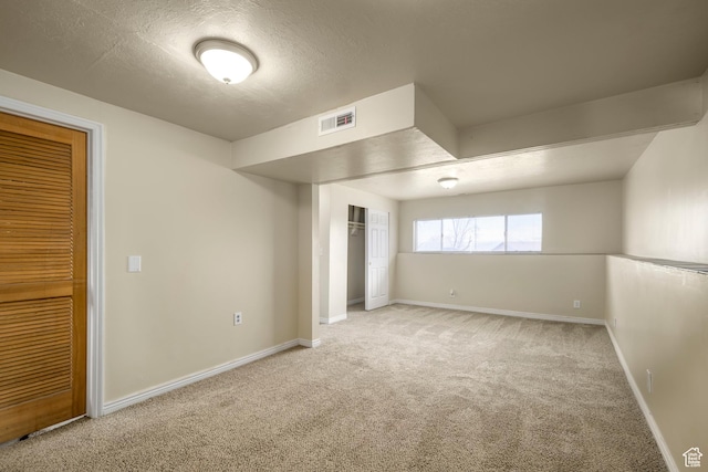 unfurnished bedroom featuring carpet flooring, baseboards, visible vents, and a textured ceiling