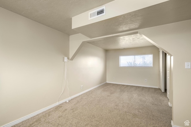 bonus room with visible vents, a textured ceiling, baseboards, and carpet floors