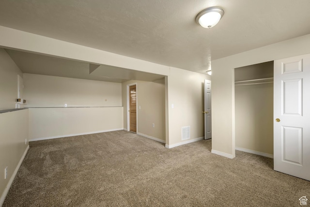 basement featuring visible vents, carpet floors, and baseboards
