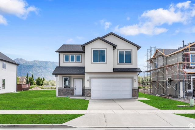 view of front facade featuring a front yard, a garage, driveway, and stucco siding