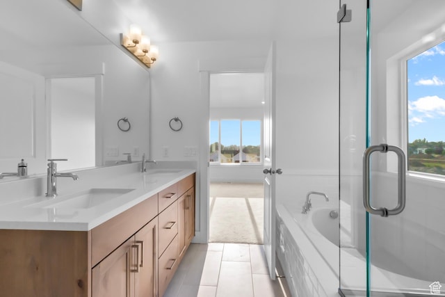 bathroom with a sink, a relaxing tiled tub, double vanity, and tile patterned floors