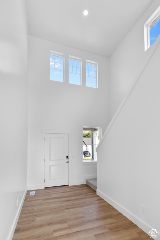 entrance foyer featuring a high ceiling, recessed lighting, baseboards, and light wood-type flooring