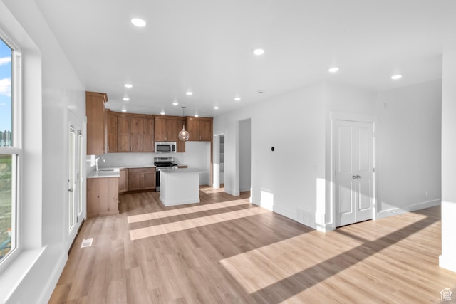 kitchen with a sink, light countertops, recessed lighting, and stainless steel appliances