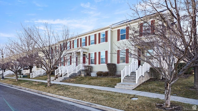 townhome / multi-family property featuring a front lawn and fence