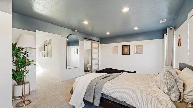 bedroom with baseboards, visible vents, recessed lighting, light carpet, and a barn door