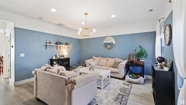 living area featuring visible vents, baseboards, recessed lighting, light wood-style floors, and a notable chandelier