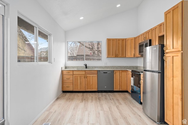 kitchen featuring lofted ceiling, recessed lighting, a sink, stainless steel appliances, and light wood-style floors
