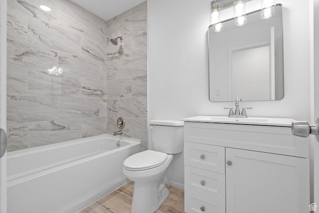 bathroom with vanity, wood finished floors, baseboards, tub / shower combination, and toilet