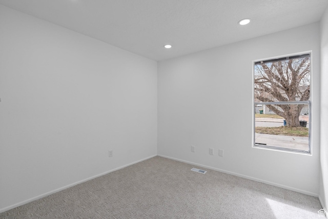 carpeted spare room featuring recessed lighting, visible vents, a healthy amount of sunlight, and baseboards