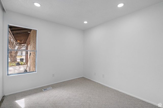 unfurnished room featuring visible vents, recessed lighting, carpet flooring, and baseboards