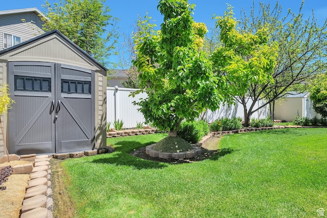 view of yard featuring an outbuilding, a storage unit, and fence