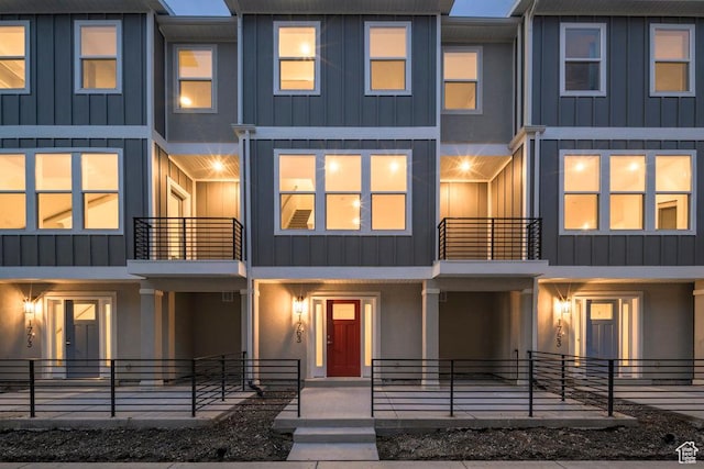 townhome / multi-family property featuring a porch, board and batten siding, and stucco siding