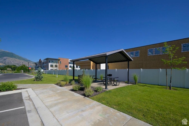 view of patio / terrace with fence and a mountain view