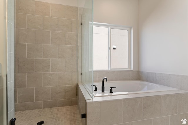 bathroom with a stall shower and a bath