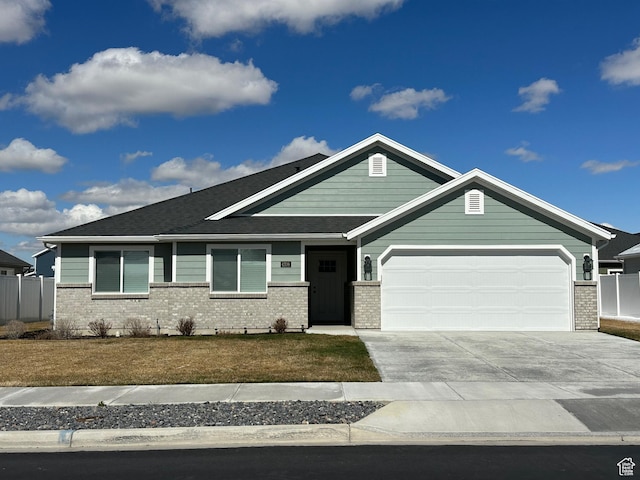 view of front of property with fence, a garage, concrete driveway, brick siding, and a front lawn