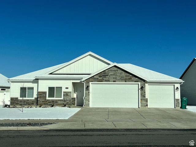 view of front of property featuring stone siding, board and batten siding, concrete driveway, and an attached garage