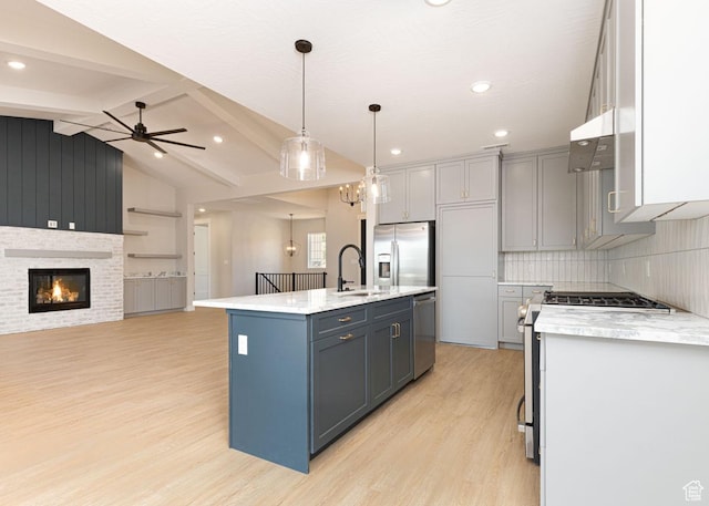 502 S Foundation Trl, Cedar City, UT 84720 - kitchen featuring stainless steel appliances, light wood finished floors, under cabinet range hood, an island with sink, and open floor plan