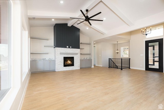 502 S Foundation Trl, Cedar City, UT 84720 - unfurnished living room featuring a chandelier, light wood finished floors, a ceiling fan, and a lit fireplace