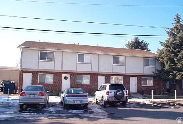multi unit property featuring uncovered parking and brick siding