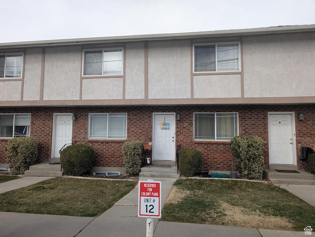 556 W 800 N Unit 18, Provo, UT 84601 - view of property featuring stucco siding, brick siding, and a front lawn