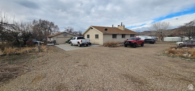 1433 W 2060 N, Helper, UT 84526 - view of side of home with driveway, a chimney, brick siding, and an outbuilding