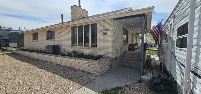 1433 W 2060 N, Helper, UT 84526 - view of side of property with brick siding, a chimney, central air condition unit, and covered porch
