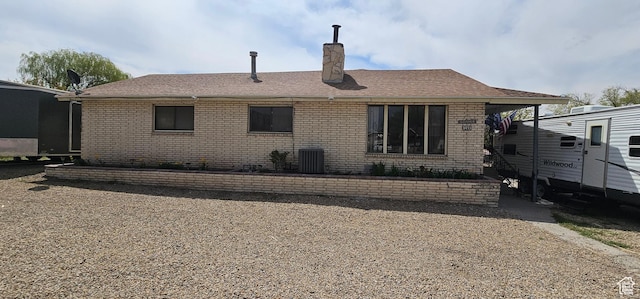 1433 W 2060 N, Helper, UT 84526 - rear view of house with brick siding, a chimney, central AC, and roof with shingles