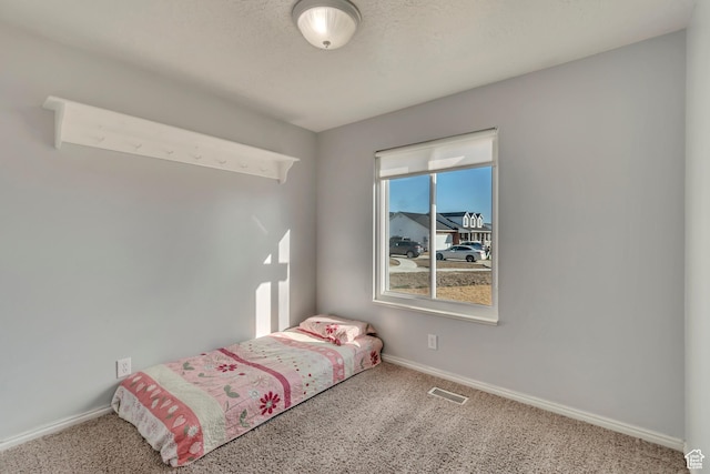unfurnished bedroom featuring carpet flooring, visible vents, and baseboards