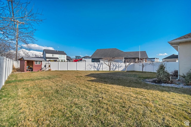 view of yard featuring an outdoor structure and a fenced backyard