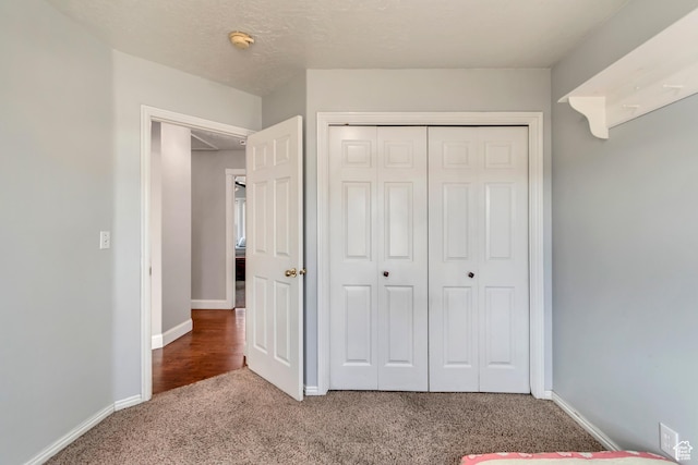 unfurnished bedroom featuring a closet, baseboards, and carpet