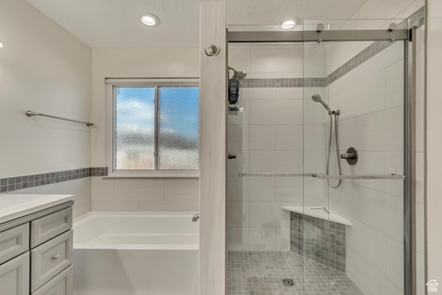 bathroom featuring vanity, a garden tub, and a stall shower