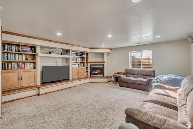 living room featuring a glass covered fireplace, recessed lighting, and carpet floors