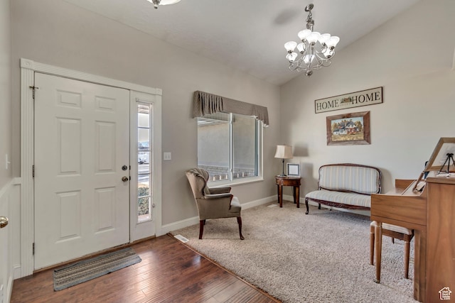 foyer featuring wood finished floors, baseboards, visible vents, an inviting chandelier, and vaulted ceiling