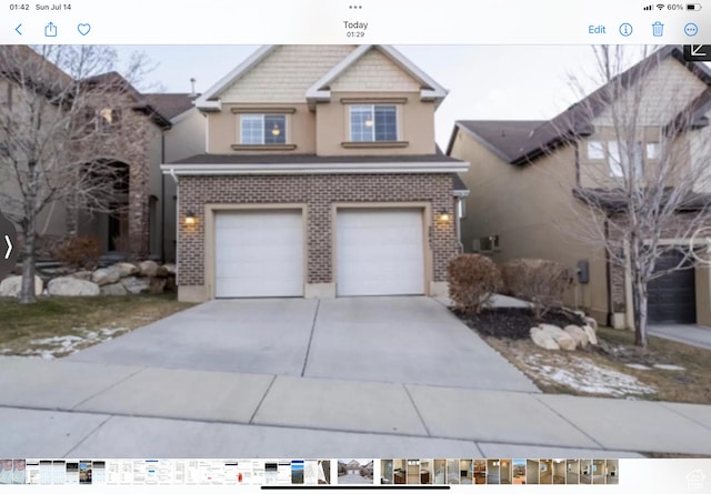 view of front of property with driveway, brick siding, and an attached garage